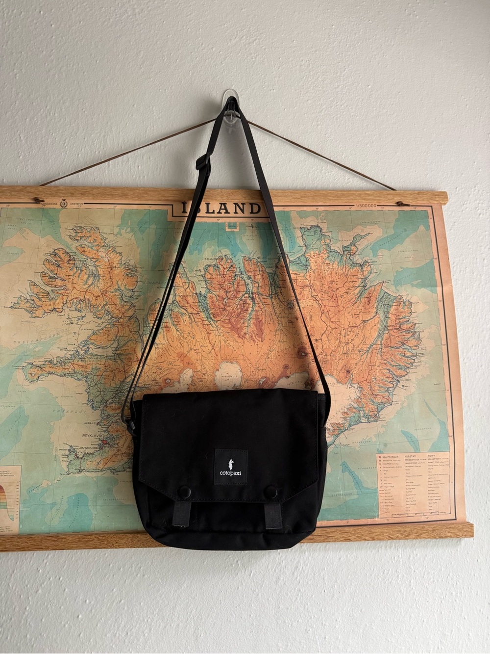 cotopaxi black messenger bag with adjustable strap